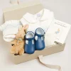 First Outfits | Gifting | Pepa London Gift boxes | Off White and Blue Hand Smocked Baby Bonnet | Plain high socks - Cream (0mths-10yrs) | Leather T-Bar Pram Shoes in Classic Blue (17-20EU) | My First Bunny in a Box - Blue