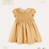 Lookbooks | Pepa London Hand Smocked Peter Pan Collar Short Sleeve Dress in Beige (12mths-10yrs) | Openwork Cotton Cardigan in Cream (6mths-10yrs) | Mary Jane Leather Baby Shoes in Ivory (20-24EU) | Traditional Big Bow Tulle Hairband in Ivory | Celebration Short Socks with Ruffle- Cream (0mths-10yrs)