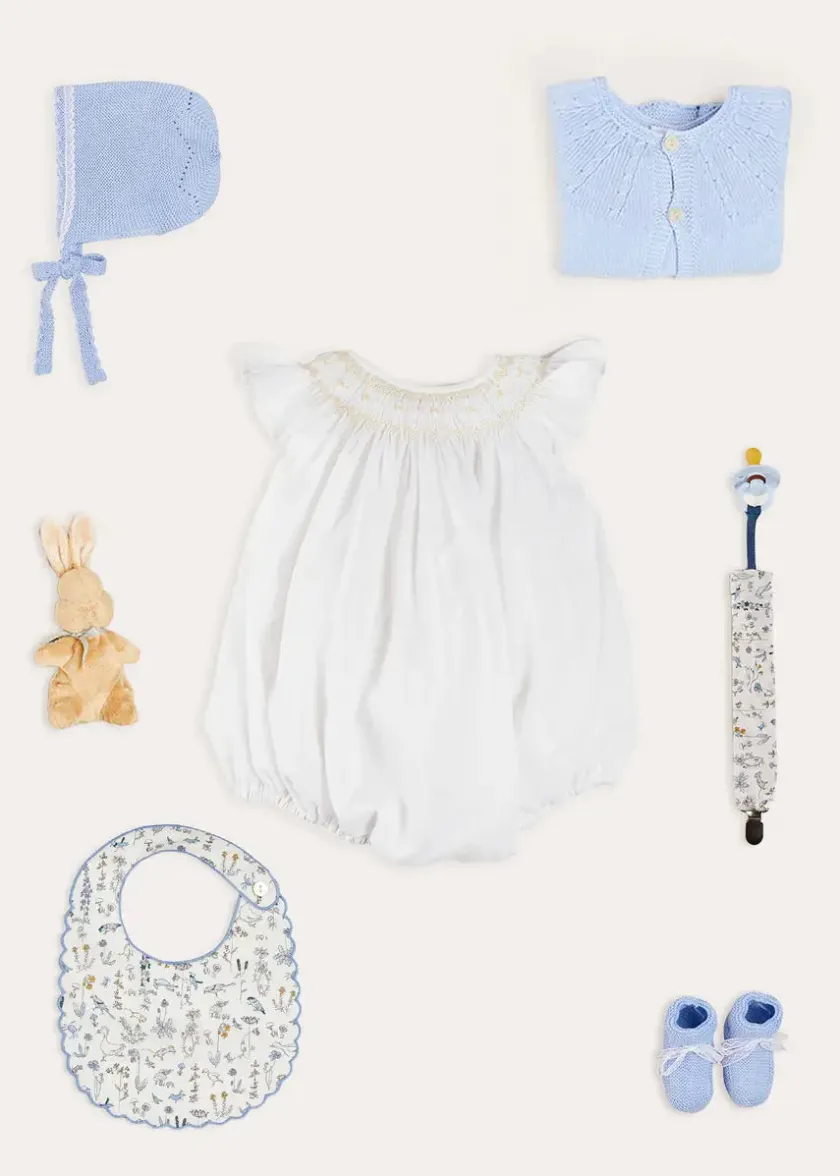 Lookbooks | Pepa London Hand Smocked Sleeveless Romper in White (3-18mths) | Openwork Detail Baby Cardigan in Blue (1-12mths) | Lace Detail Knitted Bonnet in Blue (1-6mths) | Ellis Rounded Bib with Embroidery in Blue Made with Liberty Fabric | Lace Detail Knitted Booties in Blue | Ellis Dummy Clip in Blue Made with Liberty Fabric | My First Bunny in a Box - Blue