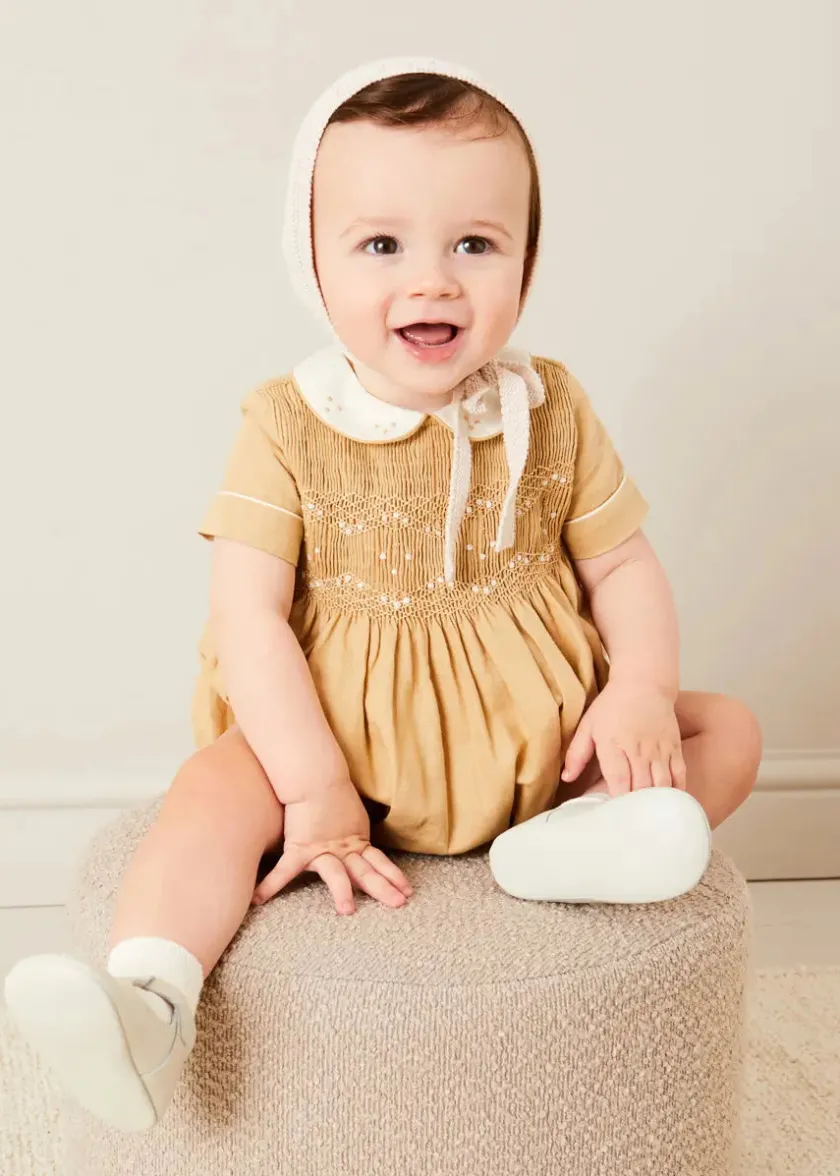 Lookbooks | Pepa London Peter Pan Collar Hand Smocked Short Sleeve Romper in Camel (6mths-2yrs) | Plain Cardigan in Cream (6mths-10yrs) | Openwork Knitted Bonnet in Beige(S-L) | T-Bar Leather Pram Shoes in Ivory (17-20EU) | Cotton Short Socks Cream (0mths-10yrs)