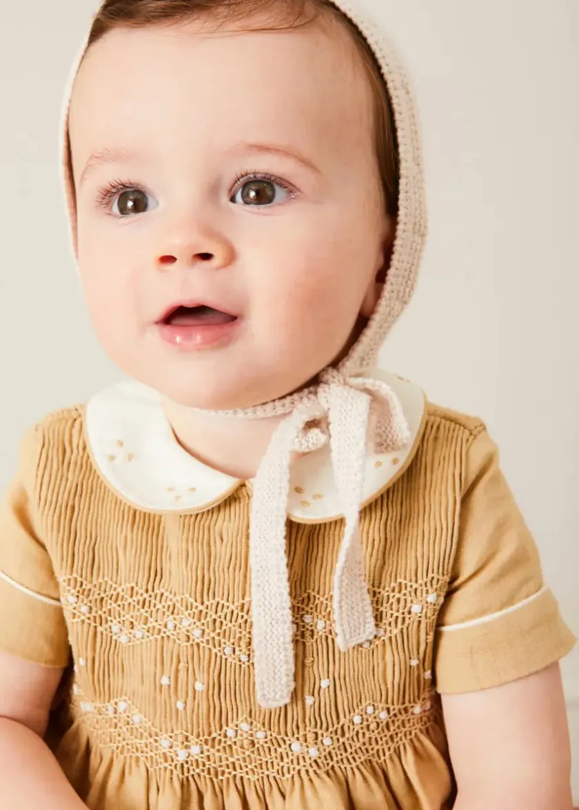 Lookbooks | Pepa London Peter Pan Collar Hand Smocked Short Sleeve Romper in Camel (6mths-2yrs) | Plain Cardigan in Cream (6mths-10yrs) | Openwork Knitted Bonnet in Beige(S-L) | T-Bar Leather Pram Shoes in Ivory (17-20EU) | Cotton Short Socks Cream (0mths-10yrs)