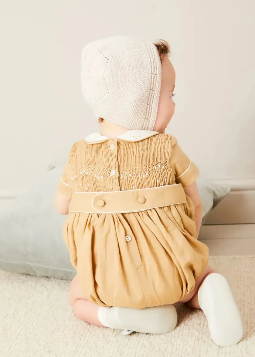 Lookbooks | Pepa London Peter Pan Collar Hand Smocked Short Sleeve Romper in Camel (6mths-2yrs) | Plain Cardigan in Cream (6mths-10yrs) | Openwork Knitted Bonnet in Beige(S-L) | T-Bar Leather Pram Shoes in Ivory (17-20EU) | Cotton Short Socks Cream (0mths-10yrs)