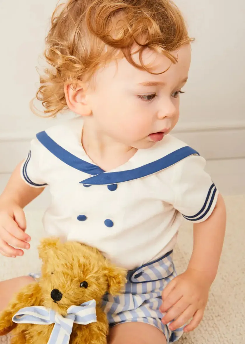 Lookbooks | Pepa London Regency Stripe Mariner Collar Two Piece Set With Bloomers in Blue (6mths-3yrs) | Plain Cardigan in Navy (6mths-10yrs) | Openwork Knitted Bonnet in Navy (S-L) | T-Bar Baby Shoes in Blue (20-26EU) | Cotton Short Socks Cream (0mths-10yrs) | Limited Edition Merrythought & Pepa Teddy Bear With Regency Striped Bow in Blue (S-L)